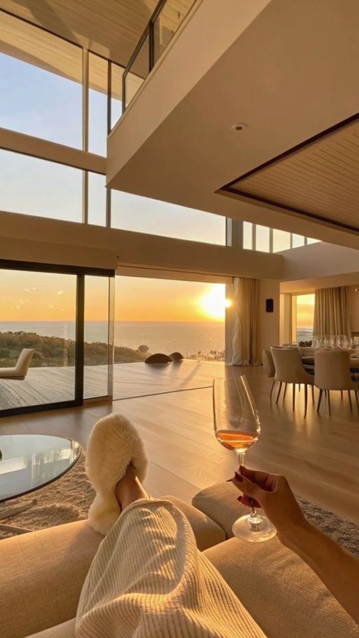 Interior amplo com vista para o mar ao pôr do sol, vivido a partir de uma zona de descanso
